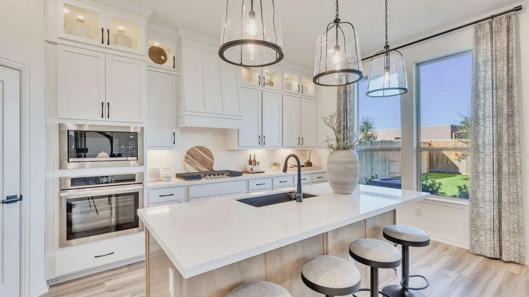 Luxurious Briarwood kitchen boasts elegant quartz counters, bespoke cabinetry, and designer pendant lighting.