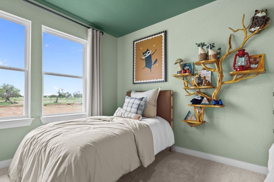 A bedroom with a bed and a shelf with art on it. A bedroom with a bed and a shelf with art on it.