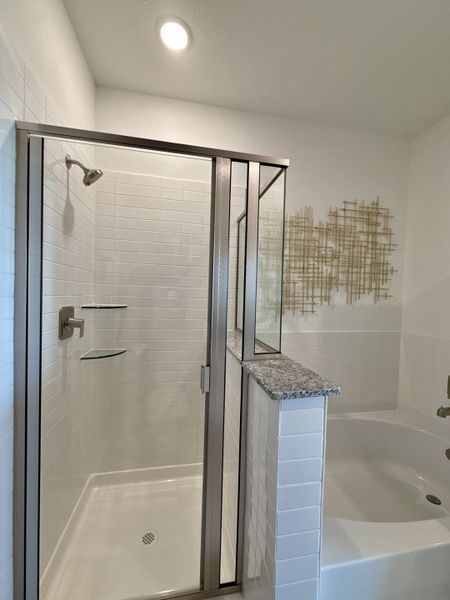 A modern bathroom with a sleek tiled shower, glass doors, and a cozy bathtub for relaxation. A modern bathroom with a sleek tiled shower, glass doors, and a cozy bathtub for relaxation.