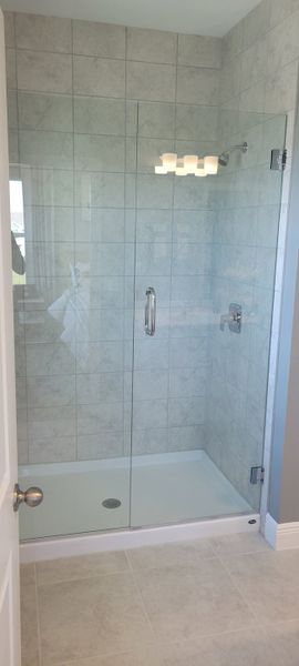 A sleek shower with a glass door and tiled walls, offering a modern, spa-like experience.
