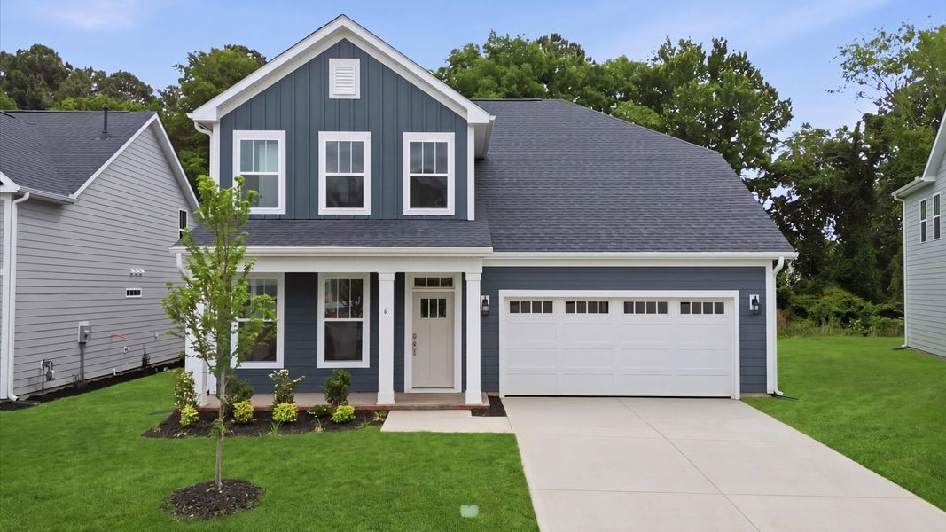 Two story home in Greenville, SC with blue exterior, two car garage, and columns at Pelham Crossing by DRB Homes