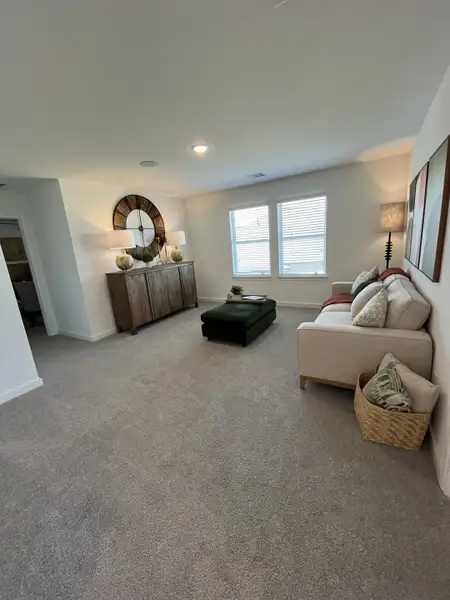 A cozy living area with plush carpeting, soft lighting, a comfortable couch, and a chic wooden sideboard. A cozy living area with plush carpeting, soft lighting, a comfortable couch, and a chic wooden sideboard.