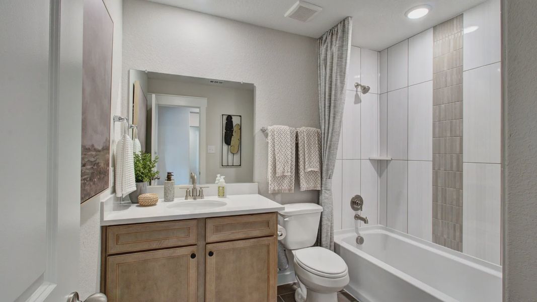 Experience refined luxury with sleek tile detail and custom wood cabinetry in Prairie Green.