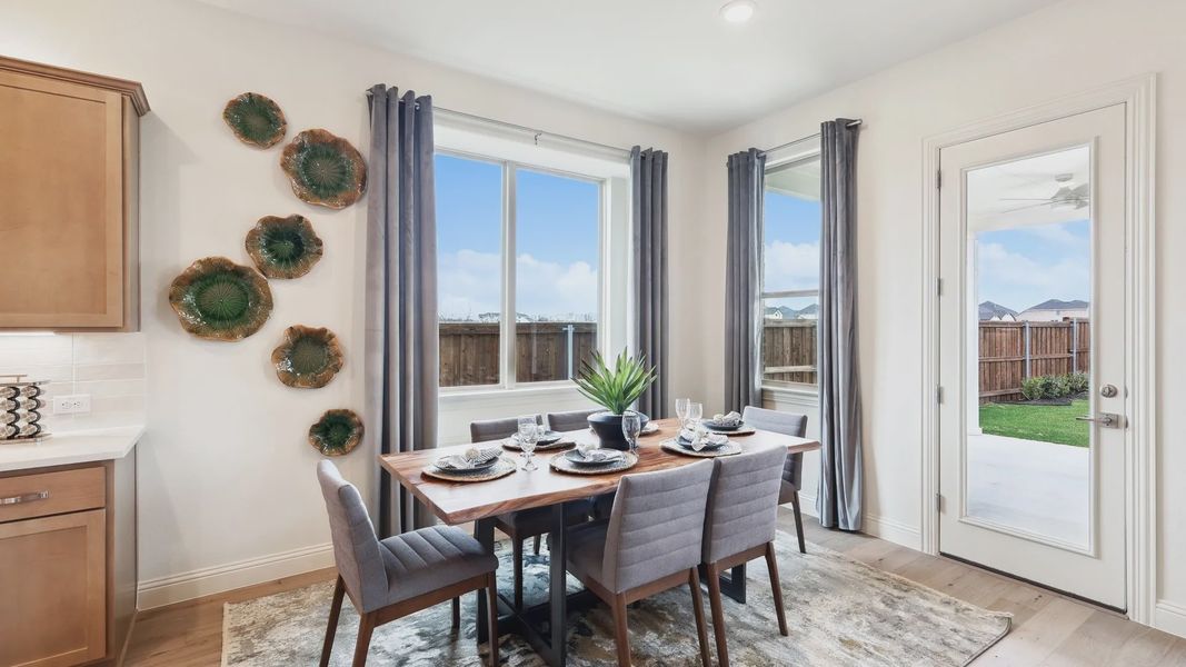 Sophisticated dining area with exquisite wood table and lush garden views in The Oaks community.