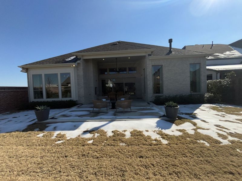 A beautiful white brick home with a spacious backyard patio in The Parks at Wilson Creek by Tradition Homes (Celina, TX). A beautiful white brick home with a spacious backyard patio in The Parks at Wilson Creek by Tradition Homes (Celina, TX).