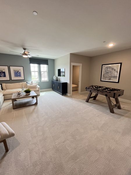 A spacious game room with plush carpeting, comfy seating, and a foosball table for entertainment. A spacious game room with plush carpeting, comfy seating, and a foosball table for entertainment.