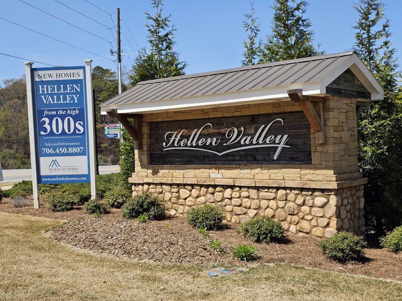 Charming entrance sign for Hellen Valley by McKinley Homes in Braselton, GA, featuring rustic stone and landscaped surroundings.