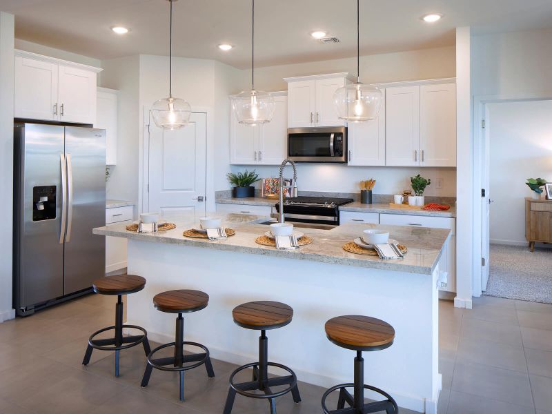 Free flowing kitchen featuring white cabinets and white granite counter tops