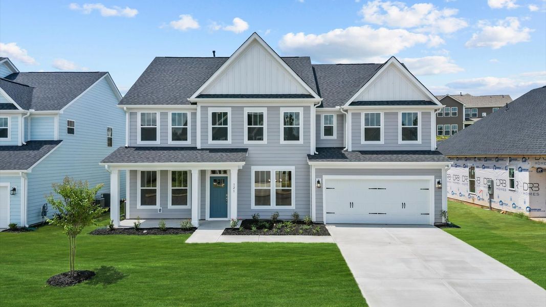 Gray exterior Stonefield floorplan two story home with blue door and two car garage at Wells Crossing by DRB Homes