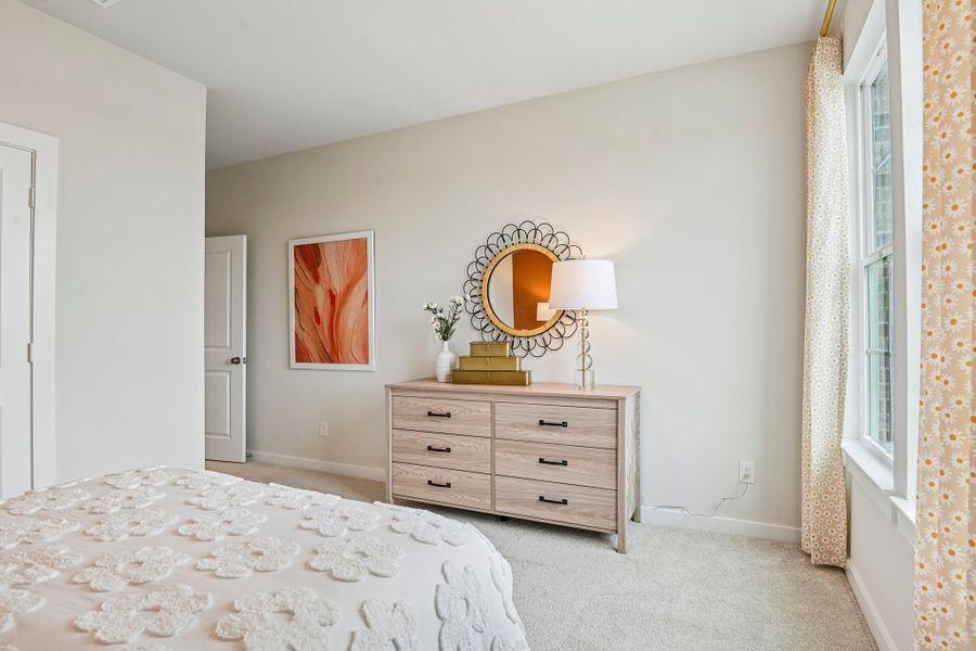 A bedroom with a mirror and dresser.