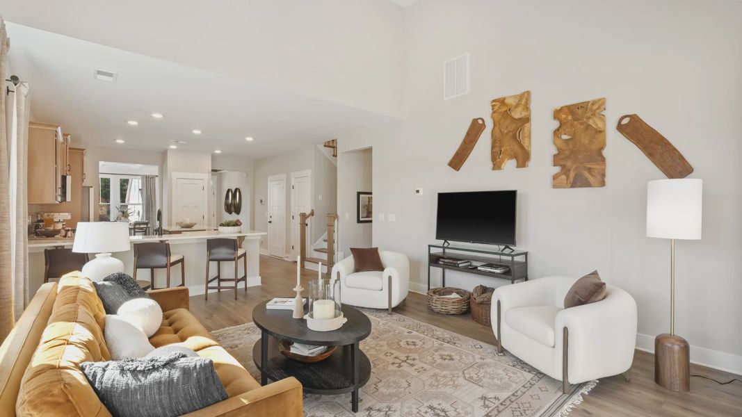 Large, open concept family room with elevated two-story ceilings and hardwood floors at Pleasant Falls in Moore, SC