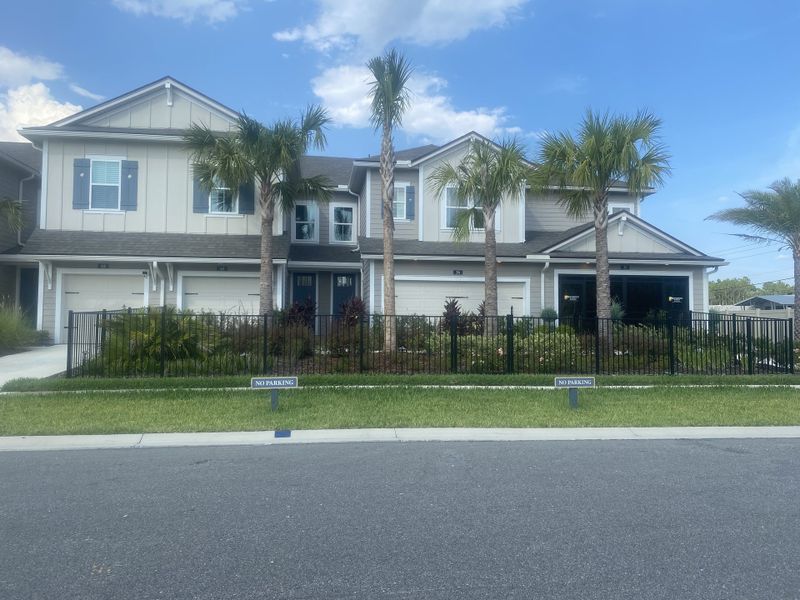 A charming modern home with palm trees and landscaped front in Woodland Park by Providence Homes (Ponte Vedra Beach, FL).