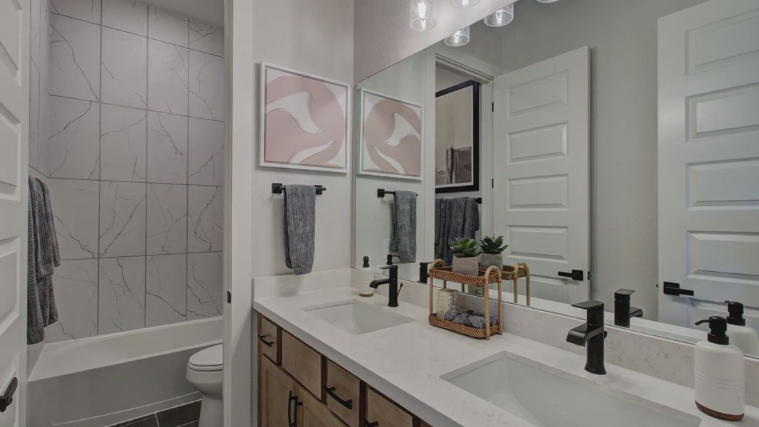 Revel in sleek marble tiles and sophisticated fixtures in this Verandas at the Rim bathroom sanctuary.