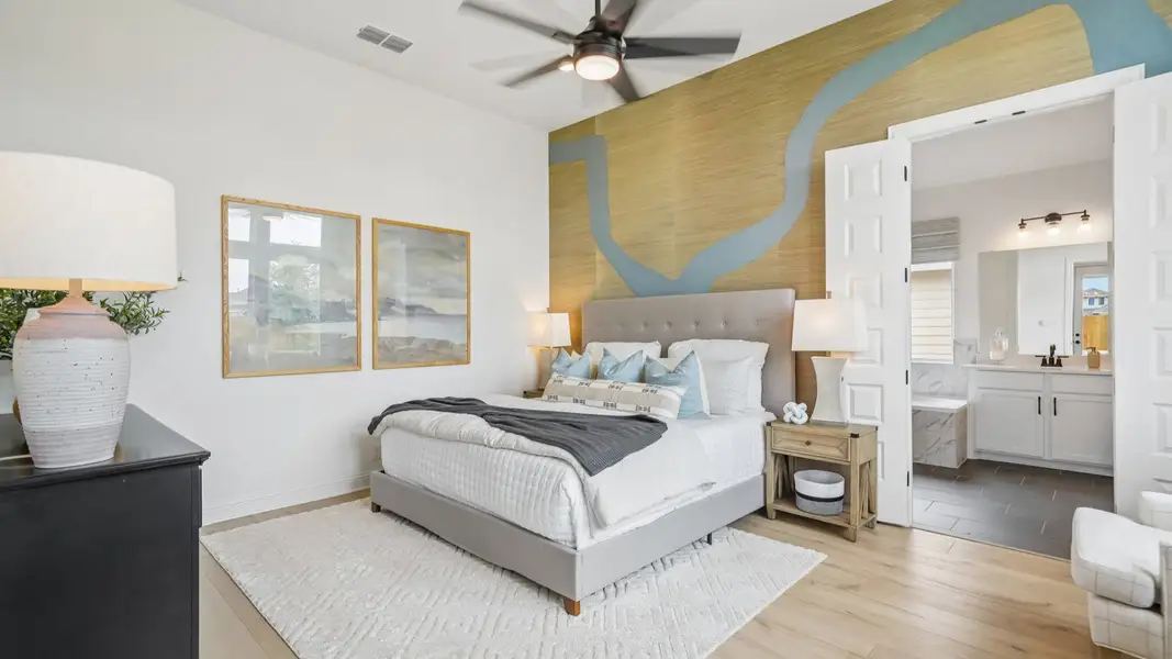 Spacious owner’s suite with sleek finishes and warm-toned flooring, plus bathroom with charcoal flooring Spacious owner’s suite with sleek finishes and warm-toned flooring, plus bathroom with charcoal flooring