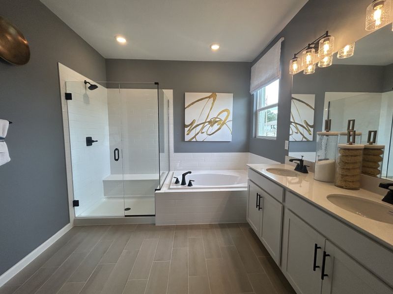 A modern bathroom featuring dual sinks, a glass shower, and elegant lighting with stylish artwork accents. A modern bathroom featuring dual sinks, a glass shower, and elegant lighting with stylish artwork accents.