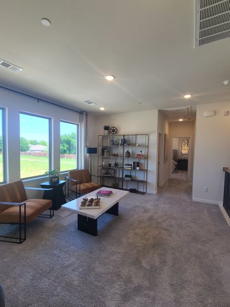 A bright living area with cozy carpet, modern chairs, a sleek coffee table, and ample natural light from large windows. A bright living area with cozy carpet, modern chairs, a sleek coffee table, and ample natural light from large windows.