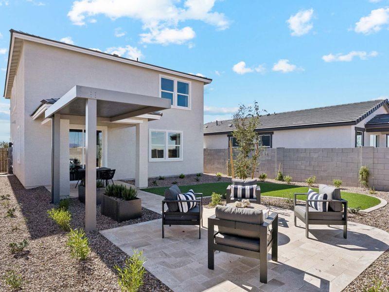 A patio with chairs and tables outside a house.