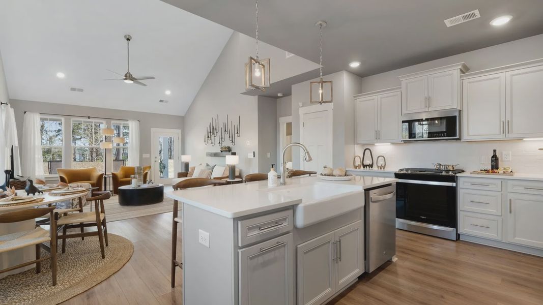 Open concept design with kitchen island overlooking the family room with two story ceilings at Village at Midway in Anderson Open concept design with kitchen island overlooking the family room with two story ceilings at Village at Midway in Anderson