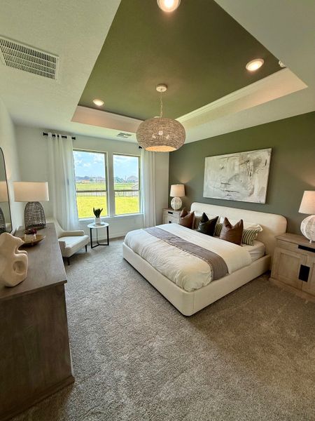 A serene bedroom with a modern accent wall, cozy bed, stylish lighting, and large windows offering a scenic view.