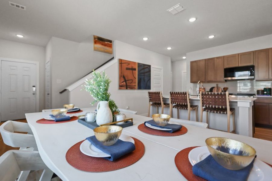 A kitchen with a table set with plates and bowls.
