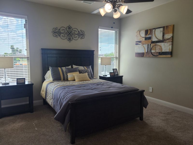 A cozy bedroom with plush carpeting, dark wood furniture, and elegant wall art, enhanced by soft natural light. A cozy bedroom with plush carpeting, dark wood furniture, and elegant wall art, enhanced by soft natural light.