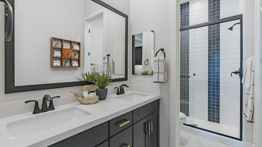 Luxurious Windrose bathroom features sleek black cabinetry and elegant glass shower.