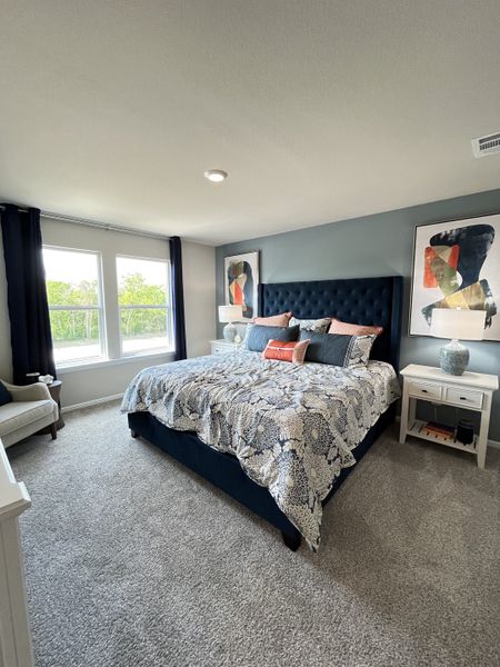 A cozy bedroom with a plush bed, abstract art, and soft carpet, featuring large windows and elegant decor. A cozy bedroom with a plush bed, abstract art, and soft carpet, featuring large windows and elegant decor.