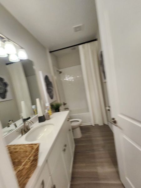 A modern bathroom featuring sleek white cabinetry, a spacious mirror, and elegant lighting with a neutral color scheme. A modern bathroom featuring sleek white cabinetry, a spacious mirror, and elegant lighting with a neutral color scheme.