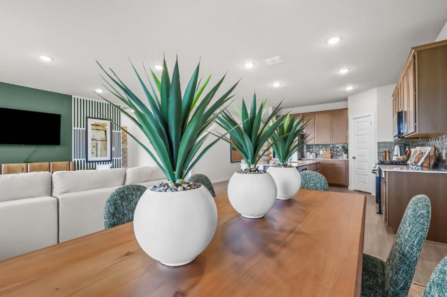 A living room with a white couch and a white table with a plant in it. A living room with a white couch and a white table with a plant in it.