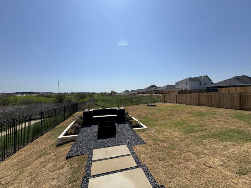 Expansive backyard with a modern patio and scenic views in Trace by D.R. Horton, San Marcos, TX. Expansive backyard with a modern patio and scenic views in Trace by D.R. Horton, San Marcos, TX.