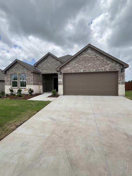 A charming brick home with a spacious driveway in Saddlebrook by D.R. Horton (Waxahachie, TX).