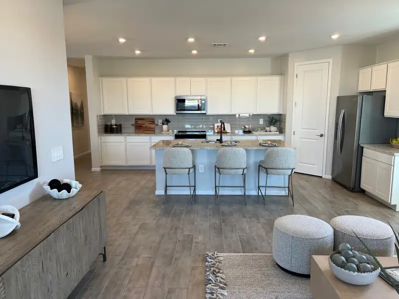 A spacious open-concept kitchen and living area with sleek cabinetry, a breakfast bar, and modern decor. A spacious open-concept kitchen and living area with sleek cabinetry, a breakfast bar, and modern decor.