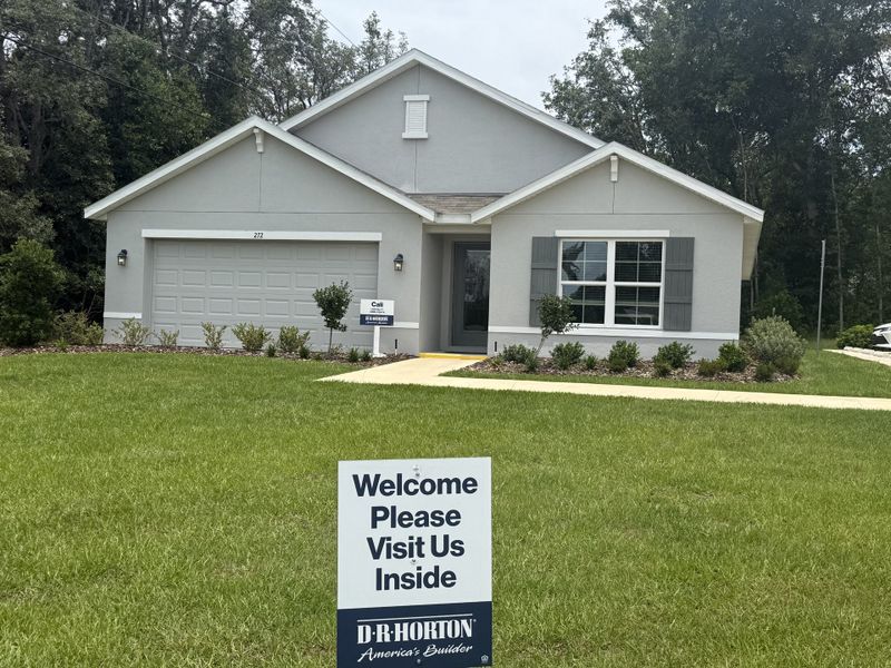 Charming gray home with shutters and a lush yard in Marion County Spot Lots by D.R. Horton (Ocala, FL).