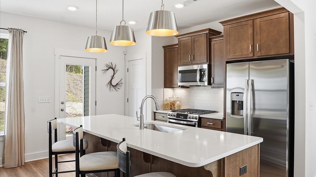 Elegant kitchen with large island and pendant lighting in this first-class DRB Homes design near Downtown Greenville