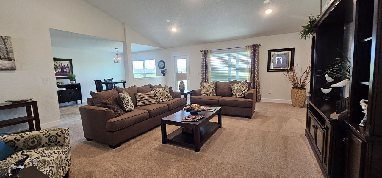 A cozy living room with plush brown sofas, patterned cushions, and elegant decor creating an inviting atmosphere.