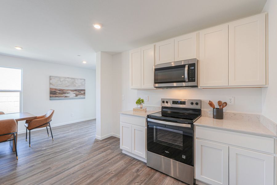 A kitchen with white cabinets.