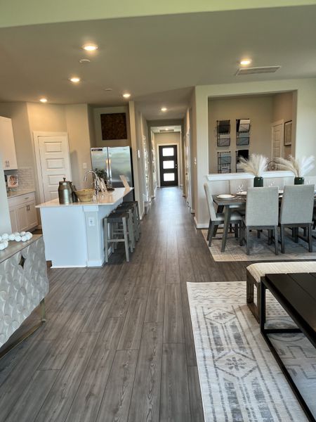 A modern open-concept kitchen and dining area with wood flooring, sleek cabinetry, and stylish decor.