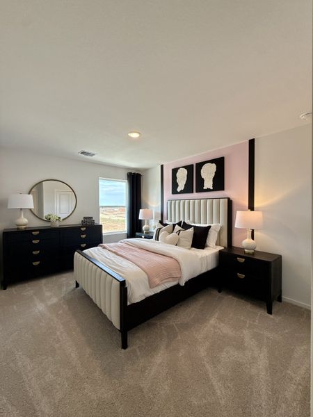 A cozy bedroom with a plush bed, elegant black furniture, artistic wall decor, and warm lighting. A cozy bedroom with a plush bed, elegant black furniture, artistic wall decor, and warm lighting.