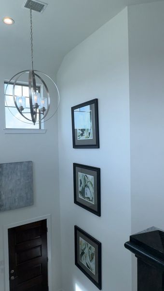 A modern hallway with abstract art, a sleek chandelier, and dark wood accents, creating a stylish entrance ambiance. A modern hallway with abstract art, a sleek chandelier, and dark wood accents, creating a stylish entrance ambiance.