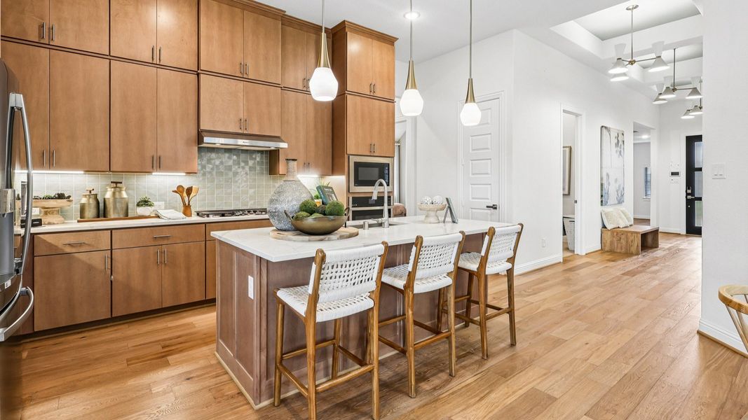 Experience luxury in Sunterra's kitchen featuring light wood cabinetry, sleek pendant lighting, and spacious island. Experience luxury in Sunterra's kitchen featuring light wood cabinetry, sleek pendant lighting, and spacious island.
