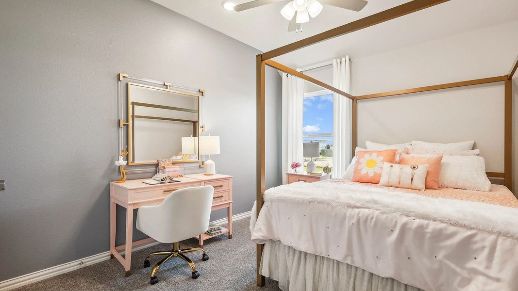 Pebblebrook bedroom features luxurious pink vanity, gold accents, plush bedding, and elegant ceiling fan.