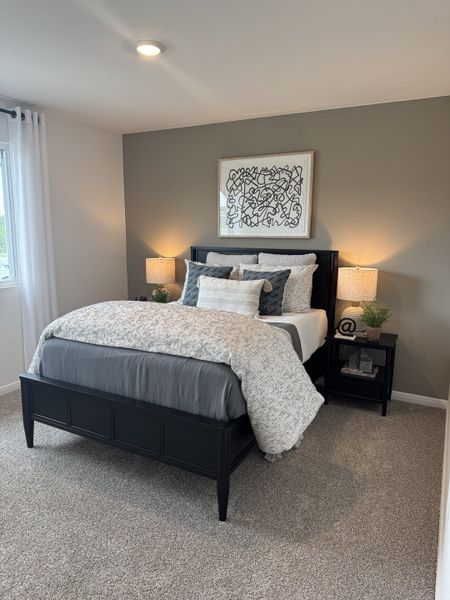 A cozy bedroom with a stylish black bedframe, modern bedside lamps, and abstract wall art for a contemporary feel. A cozy bedroom with a stylish black bedframe, modern bedside lamps, and abstract wall art for a contemporary feel.