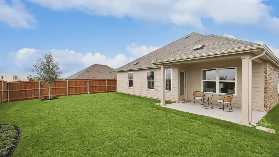 Enjoy this elegant patio and manicured lawn in Still Water Lake Estates' serene environment.