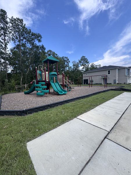 Family-friendly playground with colorful slides in Longbay Townhomes by Lennar (Middleburg, FL).