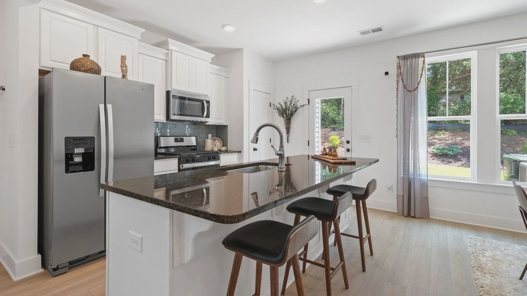 New two story townhome at Tyger Ridge in Spartanburg, SC with modern farmhouse kitchen with large island by DRB Homes New two story townhome at Tyger Ridge in Spartanburg, SC with modern farmhouse kitchen with large island by DRB Homes