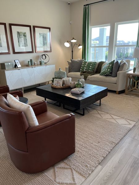 A cozy living room with elegant furnishings, earthy tones, and large windows offering ample natural light.