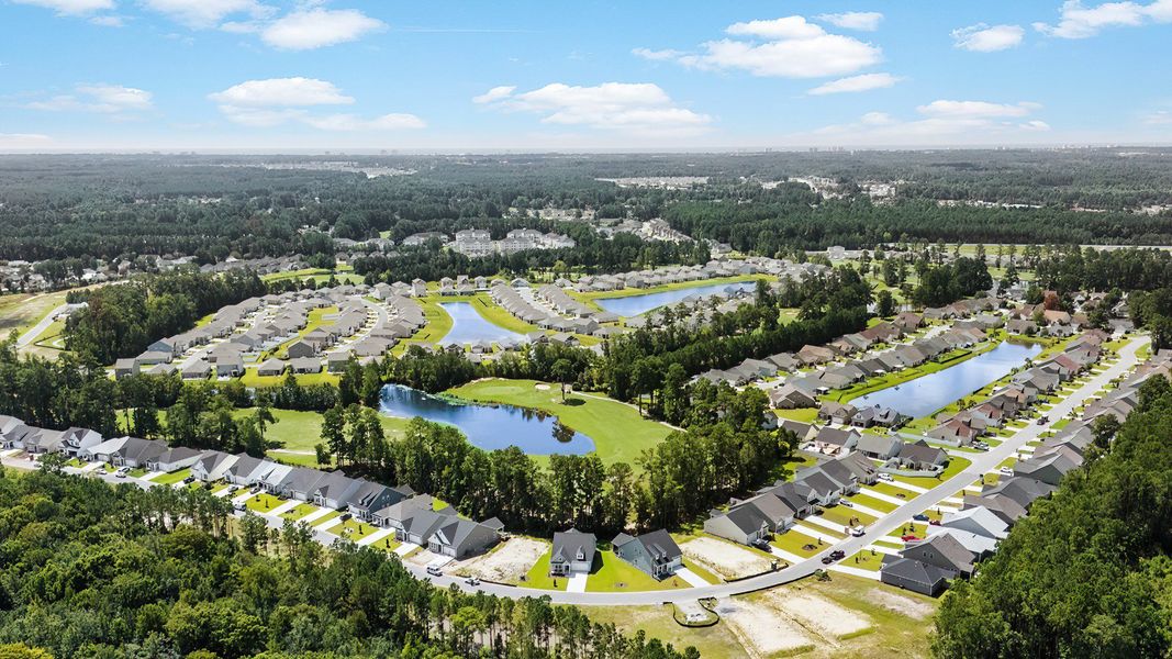 Aerial views of Bluffs at Sun Colony with water and wooded homesites on golf course.