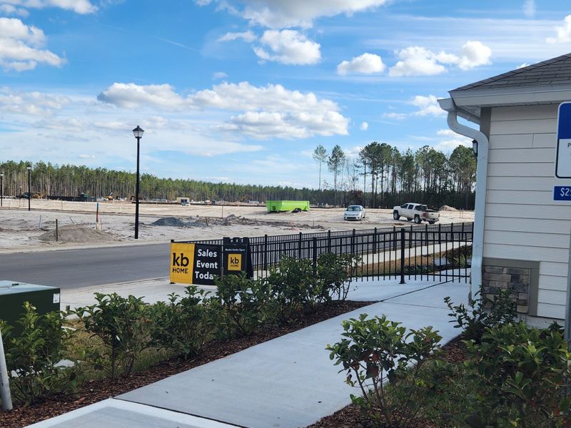 A development site with lush greenery by KB Home in Bellbrooke, Jacksonville, FL, features KB Home sales signage.
