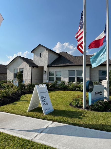 A charming white brick home with manicured landscaping in Aspire at River Ranch Trails by K. Hovnanian® Homes (Dayton, TX).