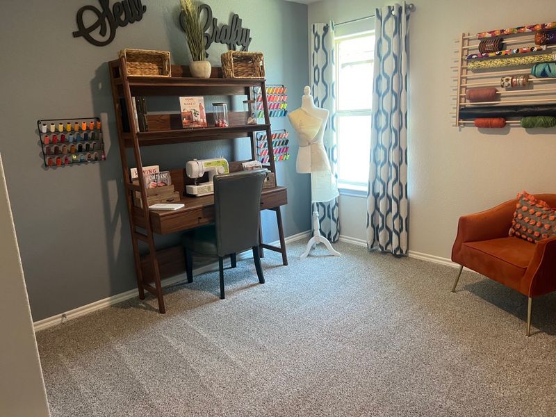 A creative sewing room with a sewing desk, mannequin, and yarn storage, featuring modern patterns and a comfy chair. A creative sewing room with a sewing desk, mannequin, and yarn storage, featuring modern patterns and a comfy chair.